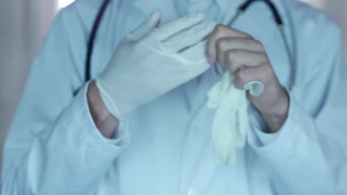 Doctor Removing Medical Gloves in Hospital Setting