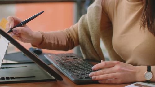Woman Drawing on Tablet at Desk