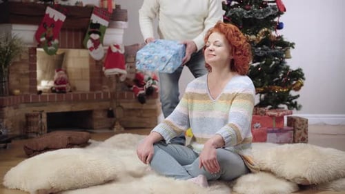 Romantic Couple Exchanging Christmas Gifts at Home