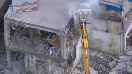 Destroying Old Concrete House Using Mechanical Arm of Bulldozer on Construction Site