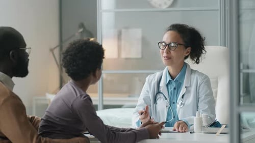 Doctor Consults with Child and Parent in Office