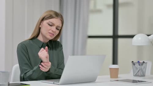 Young Woman Experiencing Wrist Pain from Computer Use