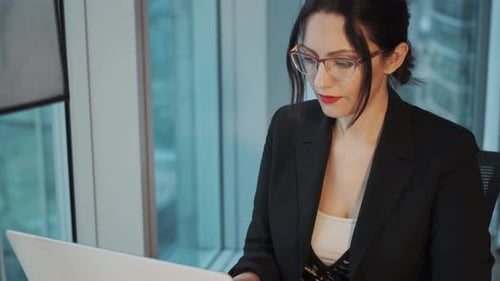 Closeup Portrait of a Young Business Woman Working at a Computer in a Modern Office