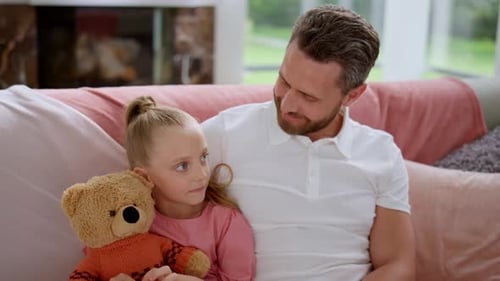 Happy Father and Daughter Cuddling on Couch