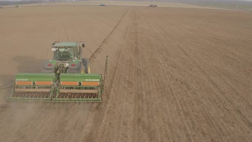Aerial view of farm tractor working in field.