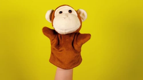 Brown Monkey Hand Puppet Waving on Yellow Background