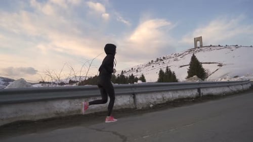 Athletic Woman Running in Snowy Mountain Landscape