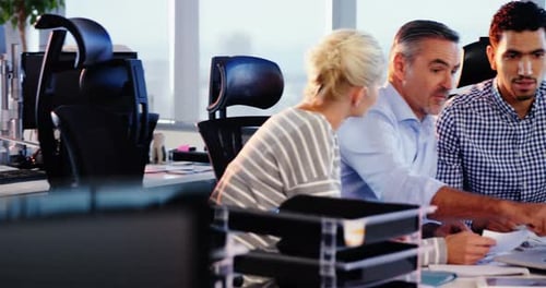 Diverse Team Collaborating on Laptop in Modern Office