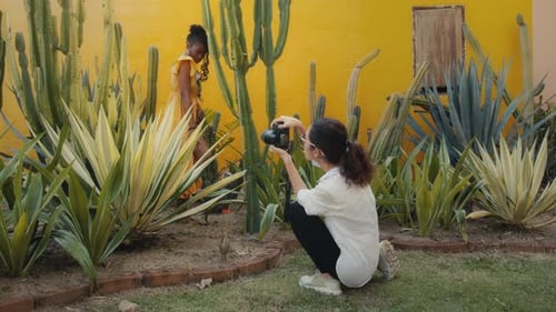 Fashionable Model Poses for Photographer in Tropical Garden