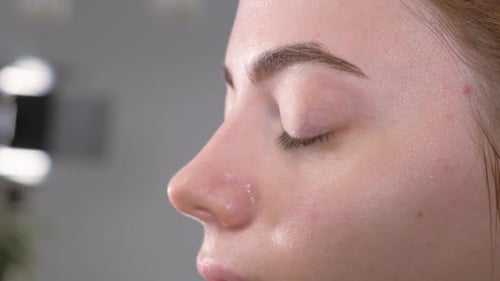 Makeup Artist Applying Makeup to Young Woman's Face
