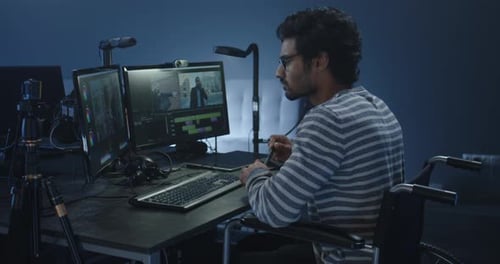 Man in Wheelchair Working at Computer Station