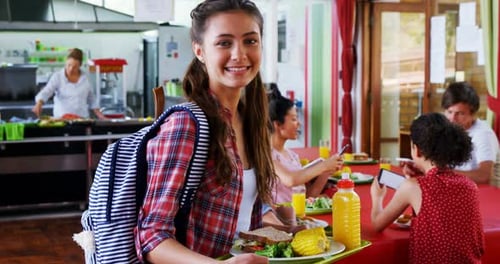 Smiling Teen Holding Lunch Tray in Cafeteria