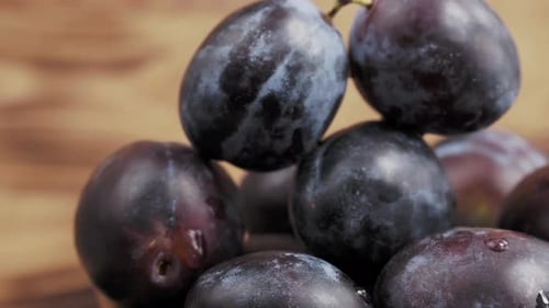 Close Up of Plums Stacked on a Wooden Table