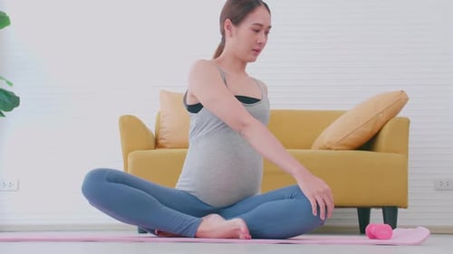 Pregnant Woman Stretching and Doing Yoga