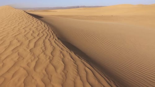 Wüstensand weht im Wind über Sanddünen