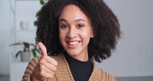 Porträt eines lächelnden afroamerikanischen Mädchens mit gemischter Rasse Teenager Aufrichtige Frau zeigt Daumen hoch Geste