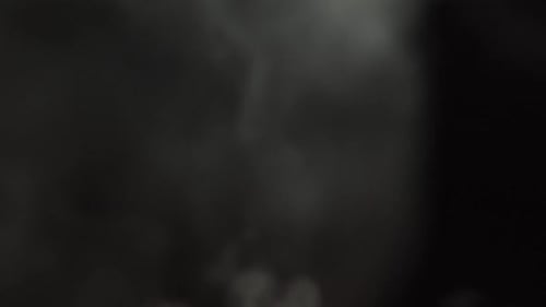 Niebla suave en cámara lenta sobre fondo oscuro. Humo gris atmosférico realista encendido