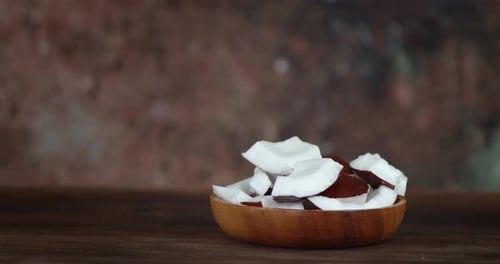 Wooden Bowl of Coconut Chunks on Table