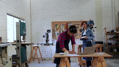 Time-lapse of Two Architect working for wood construction project on drawing paper in workshop