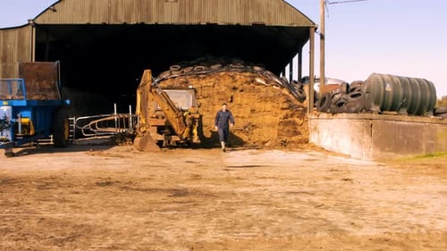 Young Man Walks Across Dirt Ground On Farm