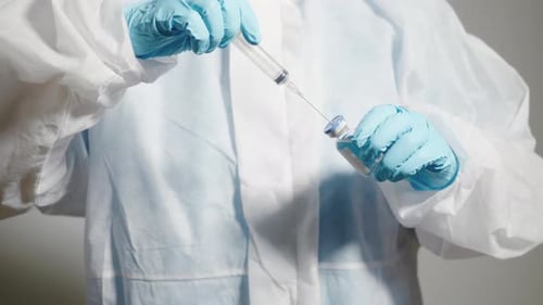 Medical Professional Drawing Vaccine into Syringe