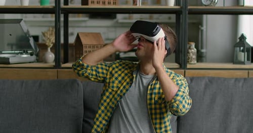 Man Experiencing Virtual Reality Headset on Sofa