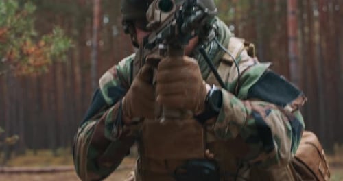 Soldier Aims Rifle in Forest, Camouflage Clothing and Gear
