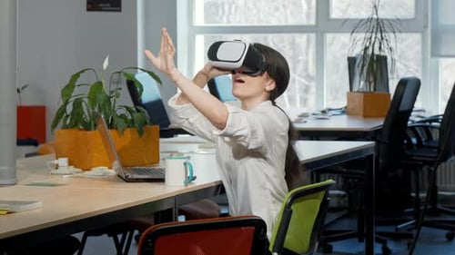Woman Interacting with VR Headset in Bright Office