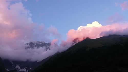 Mountain Peaks and Clouds at Vibrant Sunrise