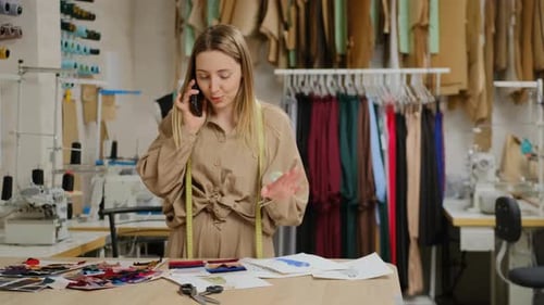Woman talking on phone in fashion design studio