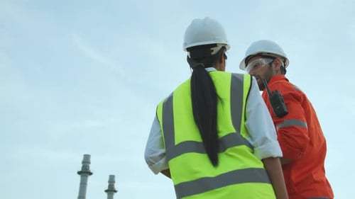 Engineers in Hard Hats Discussing Work Project