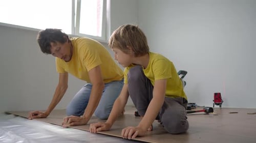 Father and Son Installing Laminate Flooring Together