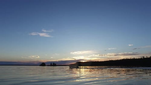 Motorboat sailing on lake at sunset