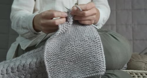 Woman Knitting a Scarf at Home
