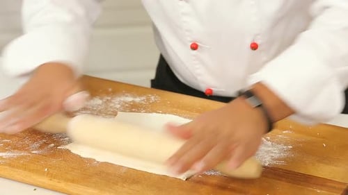 Chef Rolling Dough in Kitchen with Rolling Pin