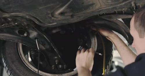 Mechanic Draining Old Brake Fluid From A System During The Service. Close Up