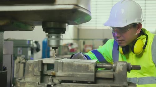Worker Uses Drill Machine in Factory Setting