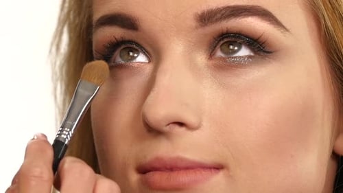 Beauty Girl with Makeup Brush. Close Up. Slow Motion