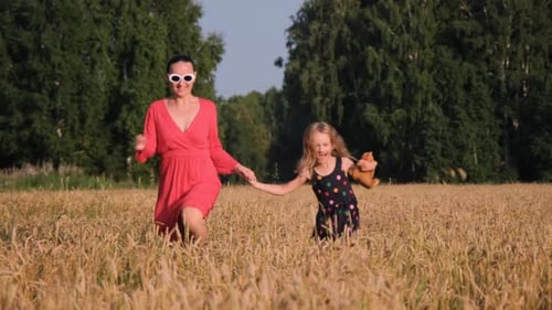 Mother with Daughter Running in a Wheat Field