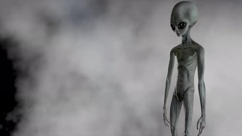 Gruseliger grauer Alien steht und sieht auf einem dunklen rauchigen Hintergrund blinkend aus
