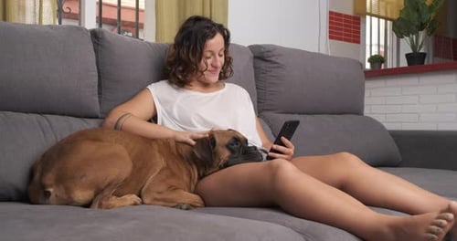 Woman Relaxes With Her Dog On Couch