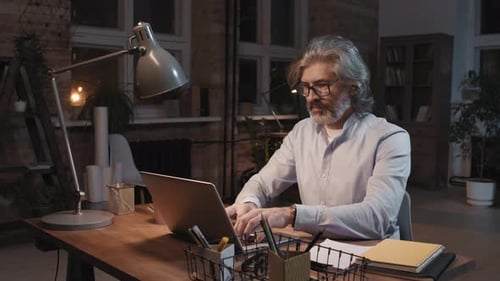 Portrait d'un accro au travail avec un ordinateur portable la nuit
