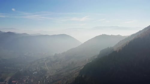 Aerial View of Mountain Ranges Peaks Shrouded in Haze and Clouds