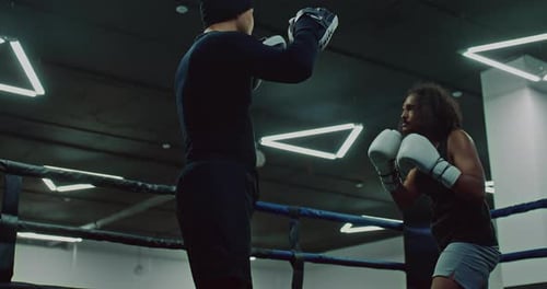 Boxer and Coach Training Together in Boxing Ring