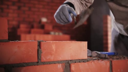 construtor coloca tijolos vermelhos em close-up