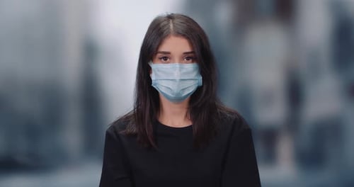 Woman Wearing Surgical Mask in Urban Setting