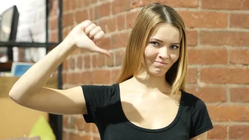 Woman Gives Thumbs Down Gesture of Disapproval
