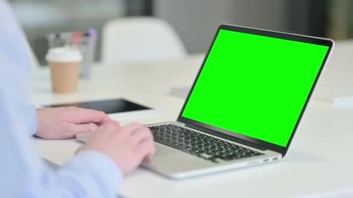 Rear View of Young Man Using Laptop with Chroma Screen