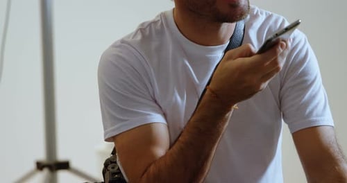 Young adult talking on smartphone in studio