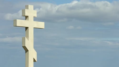 Time-Lapse of Gray Clouds Flying Over Stone Cross on Grave at the Cemetery
